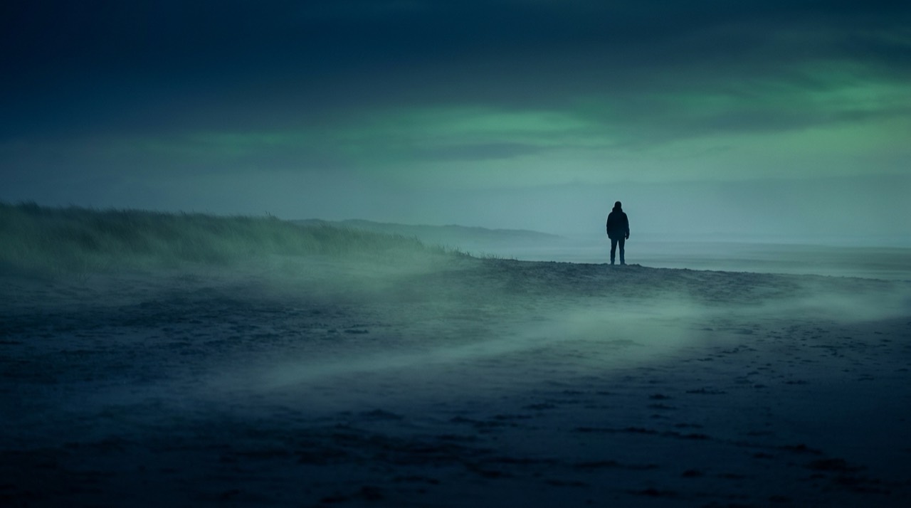 Photo : vaste horizon à l'aube, petite silhouette lointaine, ambiance contemplative bleu-vert